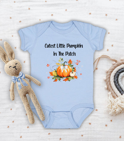 Light Blue infant bodysuit featuring the phrase "Cutest Little Pumpkin In The Patch" with an adorable fall-themed design of orange and white pumpkins, autumn leaves, hearts, and a sweet bow. Perfect for baby's first fall or pumpkin patch visit.