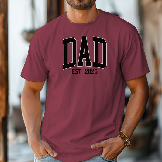 Personalized DAD Est [Year] T-shirt featuring bold varsity-style block lettering with a customizable establishment year. Printed on a soft, relaxed-fit unisex tee in chili, this design is perfect for celebrating new or seasoned fathers. Ideal for Father’s Day, birthdays, or family milestones, offering both comfort and a proud personal touch.