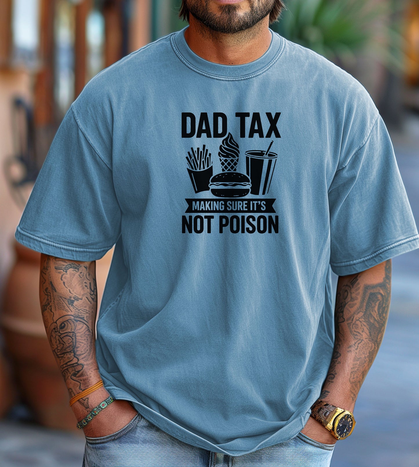 Dad Tax T-shirt featuring the humorous phrase 'Dad Tax – Making Sure It’s Not Poison' with graphics of fries, a burger, ice cream, and a drink. Printed on a washed denim unisex tee, this playful design is perfect for dads who jokingly 'sample' their kids’ food. Ideal for Father’s Day, casual wear, or gifting to food-loving fathers with a great sense of humor.