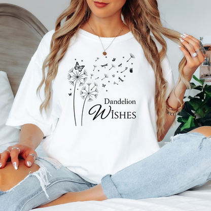 Whimsical dandelions with flying seeds, butterflies, and dragonflies pop in black and white ink against a White color Comfort Colors tee. Elegant nature motif with clean text that says "Dandelion Wishes".