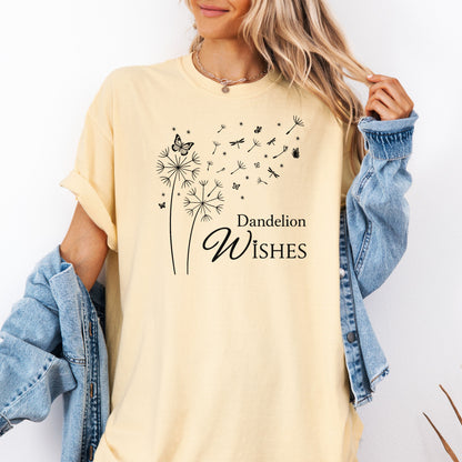 Whimsical dandelions with flying seeds, butterflies, and dragonflies pop in black and white ink against a soft butter color Comfort Colors tee. Elegant nature motif with clean text that says "Dandelion Wishes".