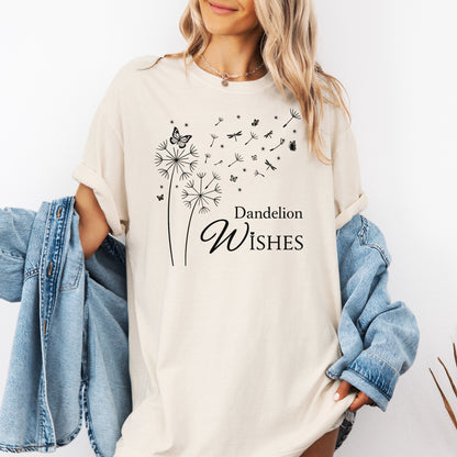 Whimsical dandelions with flying seeds, butterflies, and dragonflies pop in black and white ink against a soft Ivory color Comfort Colors tee. Elegant nature motif with clean text that says "Dandelion Wishes".