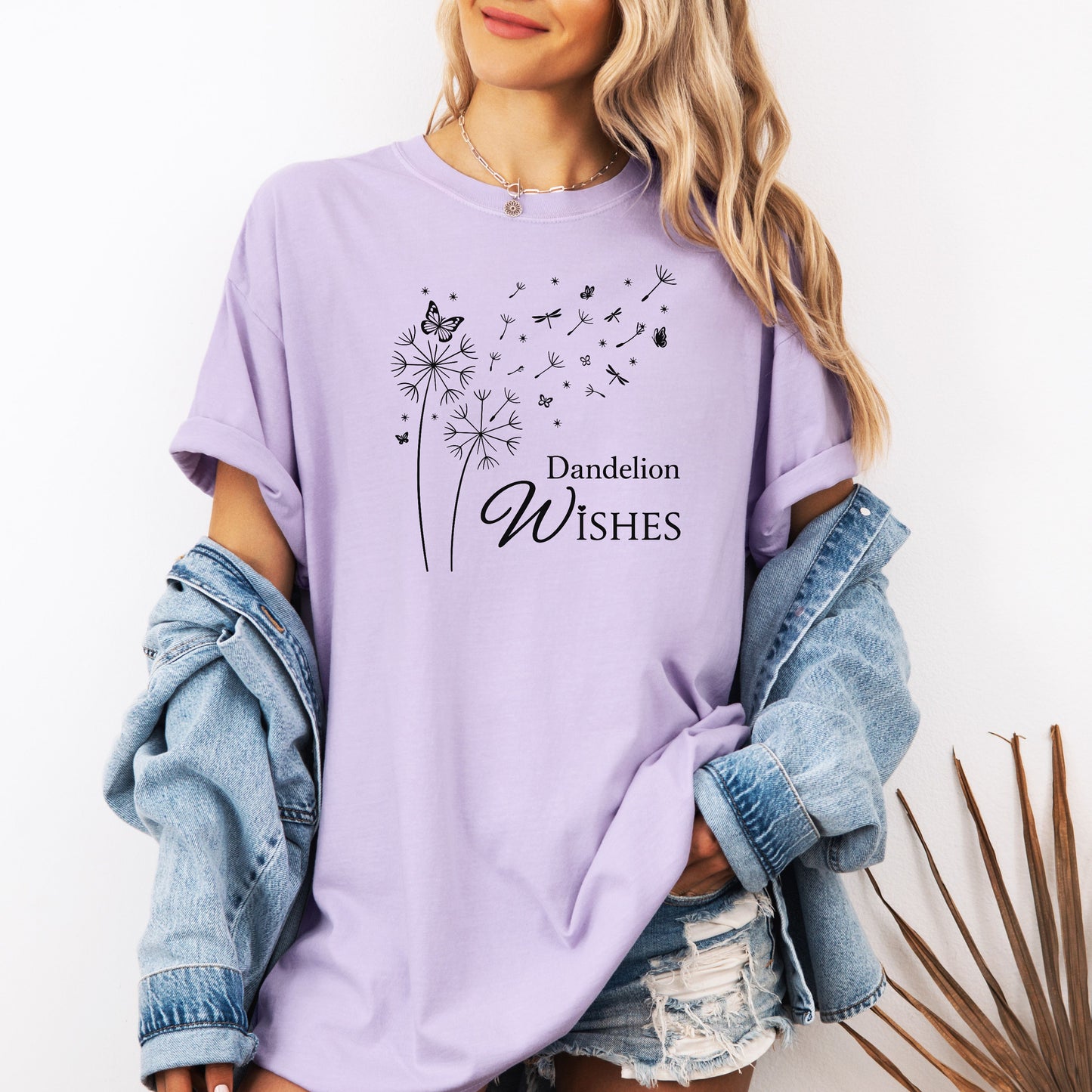 Whimsical dandelions with flying seeds, butterflies, and dragonflies pop in black and white ink against a soft Orchid color Comfort Colors tee. Elegant nature motif with clean text that says "Dandelion Wishes".