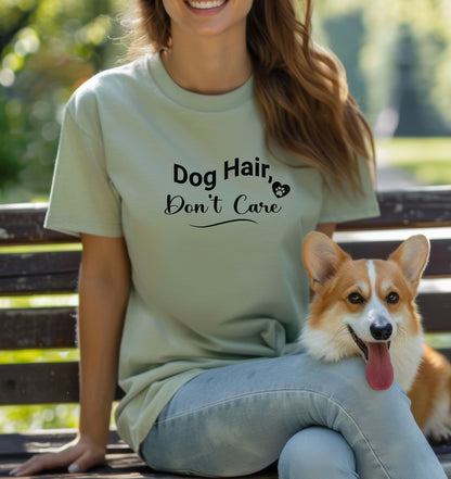 A person wearing a sage T-shirt with the playful black text “Dog Hair, Don’t Care” and a paw print accent. The design embraces the humor and love of dog ownership, making it a perfect casual fashion statement for pet lovers who proudly accept furry companionship.