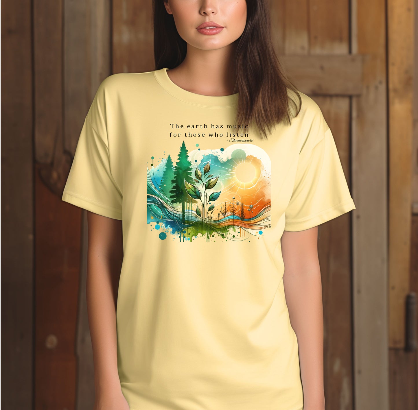 Banana T-shirt featuring a vibrant “Earth Music” nature design with the quote “The earth has music for those who listen – Shakespeare.” Artwork showcases a sunrise over green pine trees, flowing waves, and a sprouting plant, blending watercolor textures with bright greens, blues, and oranges.  This eco-inspired graphic tee celebrates the beauty and harmony of nature.