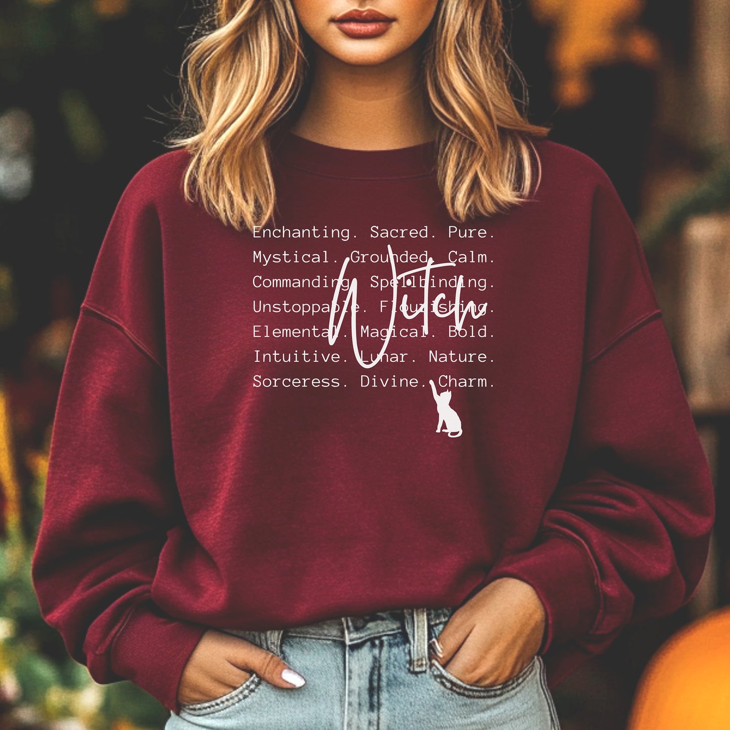 Person wearing a maroon sweatshirt with Witch text and a cat graphic, standing outdoors.