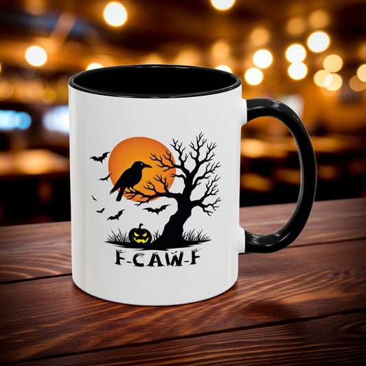 Ceramic Halloween-themed mug with "F-CAW-F" text, a crow, tree, and pumpkin on a wooden surface with blurred lights in the background.
