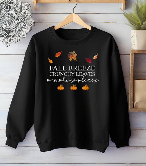 Black Gildan sweatshirt featuring a festive fall-themed design with colorful autumn leaves, the phrase “Fall Breeze, Crunchy Leaves, Pumpkins Please” in mixed fonts, and four orange pumpkin icons along the bottom. A cozy and stylish piece perfect for embracing crisp air, seasonal vibes, and pumpkin spice everything.