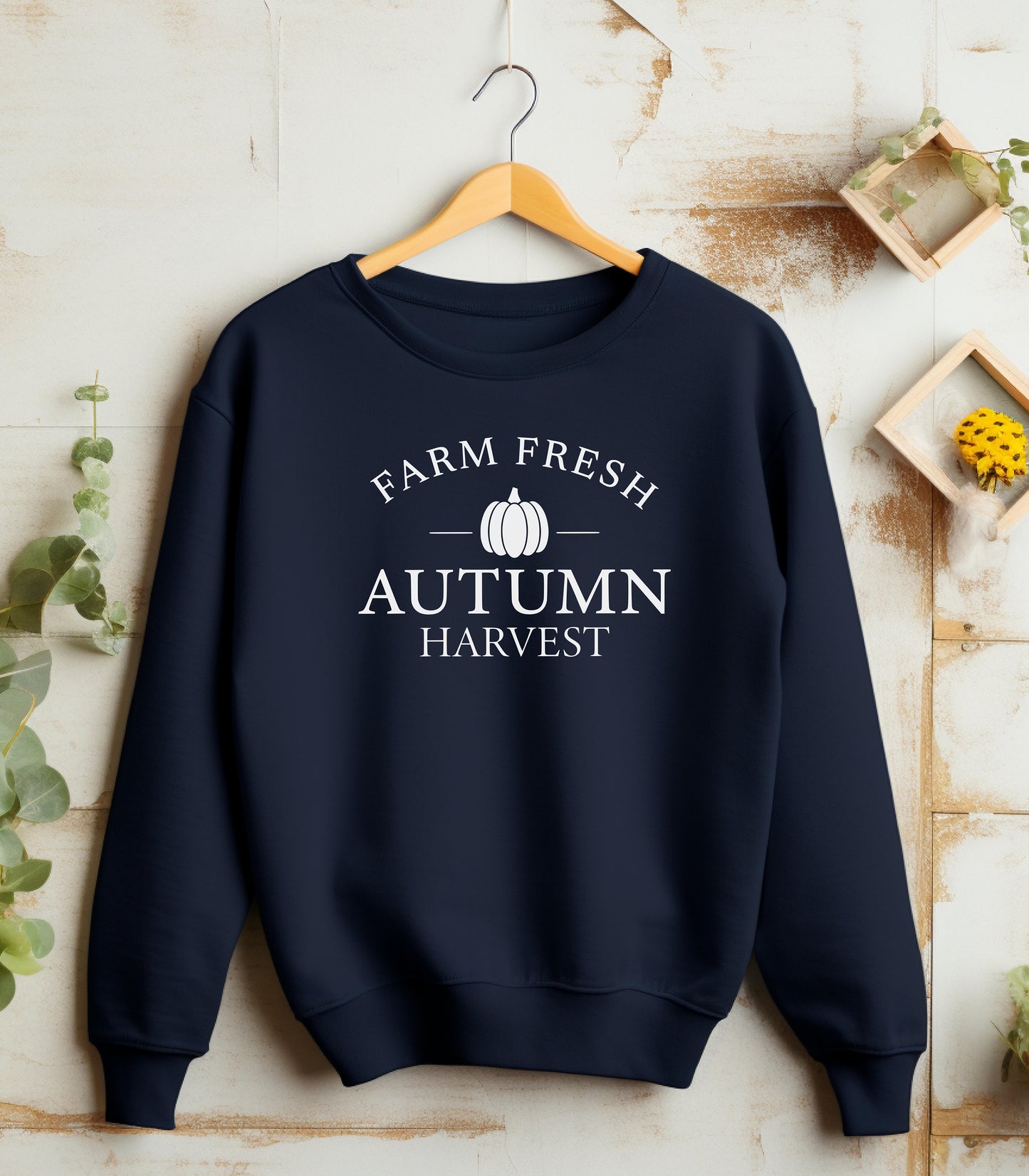Navy Gildan sweatshirt featuring a minimalist white Farm Fresh Autumn Harvest design with a simple pumpkin graphic in the center. A clean and classic fall look that captures rustic charm and seasonal spirit—perfect for farmers markets, pumpkin patches, and cozy autumn days.