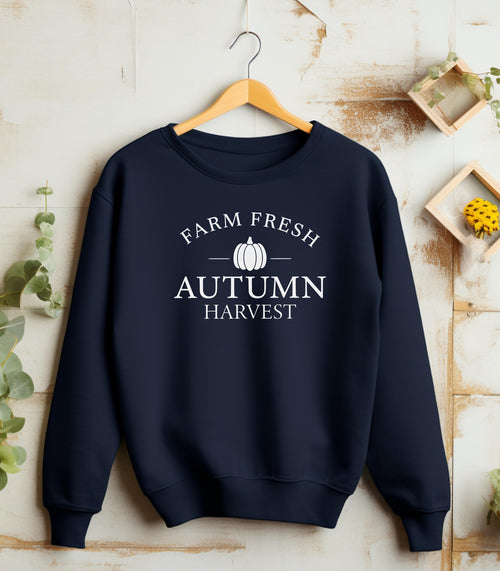 Navy Gildan sweatshirt featuring a minimalist white “Farm Fresh Autumn Harvest” design with a simple pumpkin graphic in the center. A clean and classic fall look that captures rustic charm and seasonal spirit—perfect for farmers' markets, pumpkin patches, and cozy autumn days.