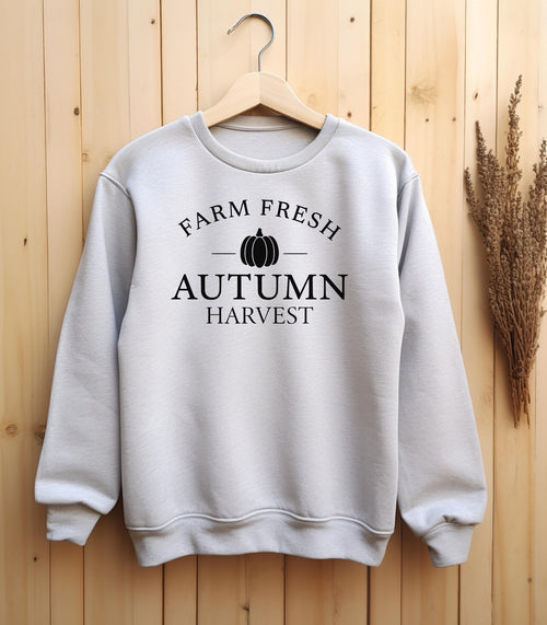 Ash Gildan sweatshirt featuring a minimalist black “Farm Fresh Autumn Harvest” design with a simple pumpkin graphic in the center. A clean and classic fall look that captures rustic charm and seasonal spirit—perfect for farmers' markets, pumpkin patches, and cozy autumn days.