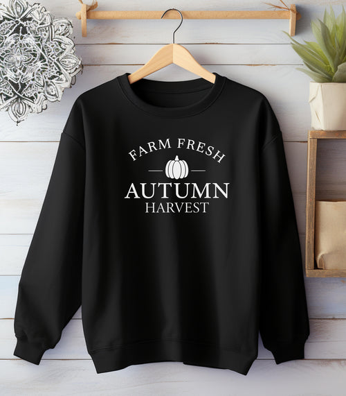 Black Gildan sweatshirt featuring a minimalist white “Farm Fresh Autumn Harvest” design with a simple pumpkin graphic in the center. A clean and classic fall look that captures rustic charm and seasonal spirit—perfect for farmers' markets, pumpkin patches, and cozy autumn days.