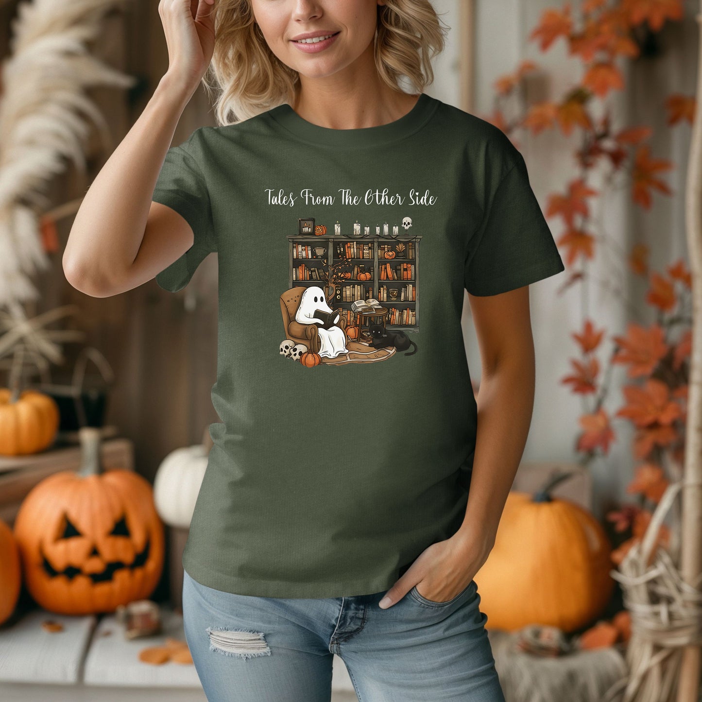 Person wearing a Hemp t-shirt featuring a cozy Halloween-themed design with a ghost reading a book in an armchair, a black cat beside it, a skull, pumpkins, and a bookshelf filled with spooky books and potion bottles. The text reads "Tales From The Other Side," creating a whimsical and gothic vibe perfect for book lovers and Halloween fans.