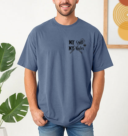 Grill Boss 'My Grill, My Rules' pocket design T-shirt featuring a bold text design with a grilling fork and flame graphic. Printed on a blue jean unisex tee, this fun and confident design is perfect for BBQ lovers, pitmasters, and backyard chefs who take charge at the grill. Ideal for summer cookouts, Father’s Day, or casual everyday wear.