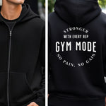 Black Gildan hoodie featuring bold white text on the back: “Stronger with Every Rep” above “GYM MODE,” with “No Pain, No Gain” curved below. A motivational fitness design that inspires dedication and strength, perfect for gym-goers committed to pushing limits and embracing an active lifestyle.