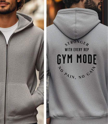Sport Grey Gildan hoodie featuring bold white text on the back: “Stronger with Every Rep” above “GYM MODE,” with “No Pain, No Gain” curved below. A motivational fitness design that inspires dedication and strength, perfect for gym-goers committed to pushing limits and embracing an active lifestyle.