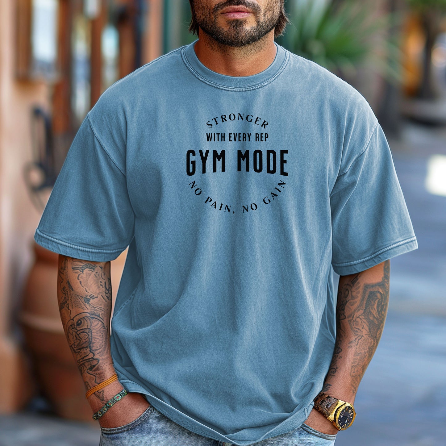 A person wearing a classic Washed Denim T-shirt with the bold black text “Stronger With Every Rep – Gym Mode – No Pain, No Gain.” The fitness-themed design features a curved text layout, perfect for workout enthusiasts and gym-goers who embrace strength training and motivation.