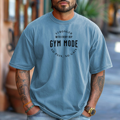 A person wearing a classic Washed Denim T-shirt with the bold black text “Stronger With Every Rep – Gym Mode – No Pain, No Gain.” The fitness-themed design features a curved text layout, perfect for workout enthusiasts and gym-goers who embrace strength training and motivation.