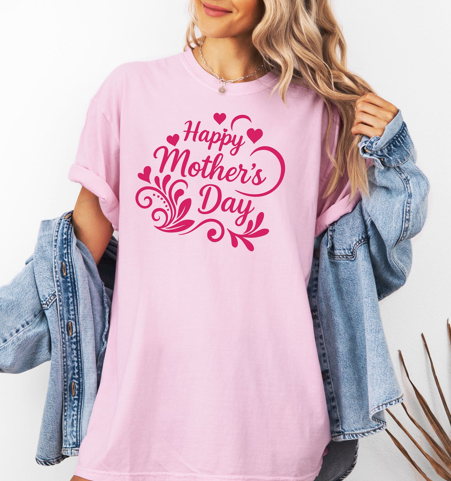 Person wearing a pink 'Happy Mother's Day' t-shirt with a denim jacket over the  shirt.