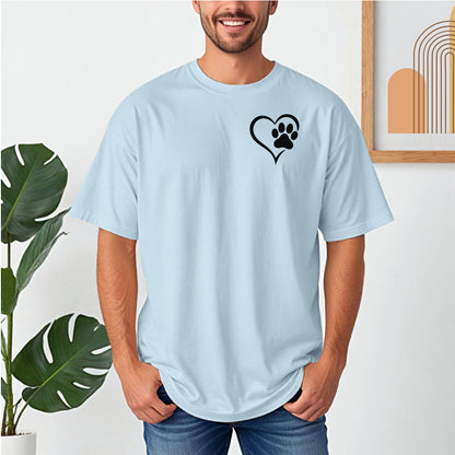 Person wearing a classic chambray light blue T-shirt featuring a simple black heart outline with a paw print inside on the upper left chest. The minimalist Heart Paw Print design symbolizes love for pets, making it a perfect shirt for dog and cat lovers.