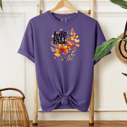 Grape T-shirt featuring a vibrant "Hello Fall" design with hand-painted autumn leaves in orange, yellow, and soft grey blue tones. The bold black lettering is accented by delicate foliage, giving this seasonal tee a cozy, cheerful, and nature-inspired look perfect for fall fashion.