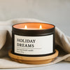 Holiday Dreams soy wax blend candle in a 8 oz black matte candle tin on a wooden coaster with a beige cloth background