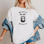 Person wearing a classic white T-shirt with the phrase “Hustle For That Muscle” in bold black text, arched above and below a detailed kettlebell graphic. The design blends minimalist style with fitness motivation, perfect for gym-goers, weightlifters, and strength training enthusiasts who embrace hard work and dedication in their workout journey.