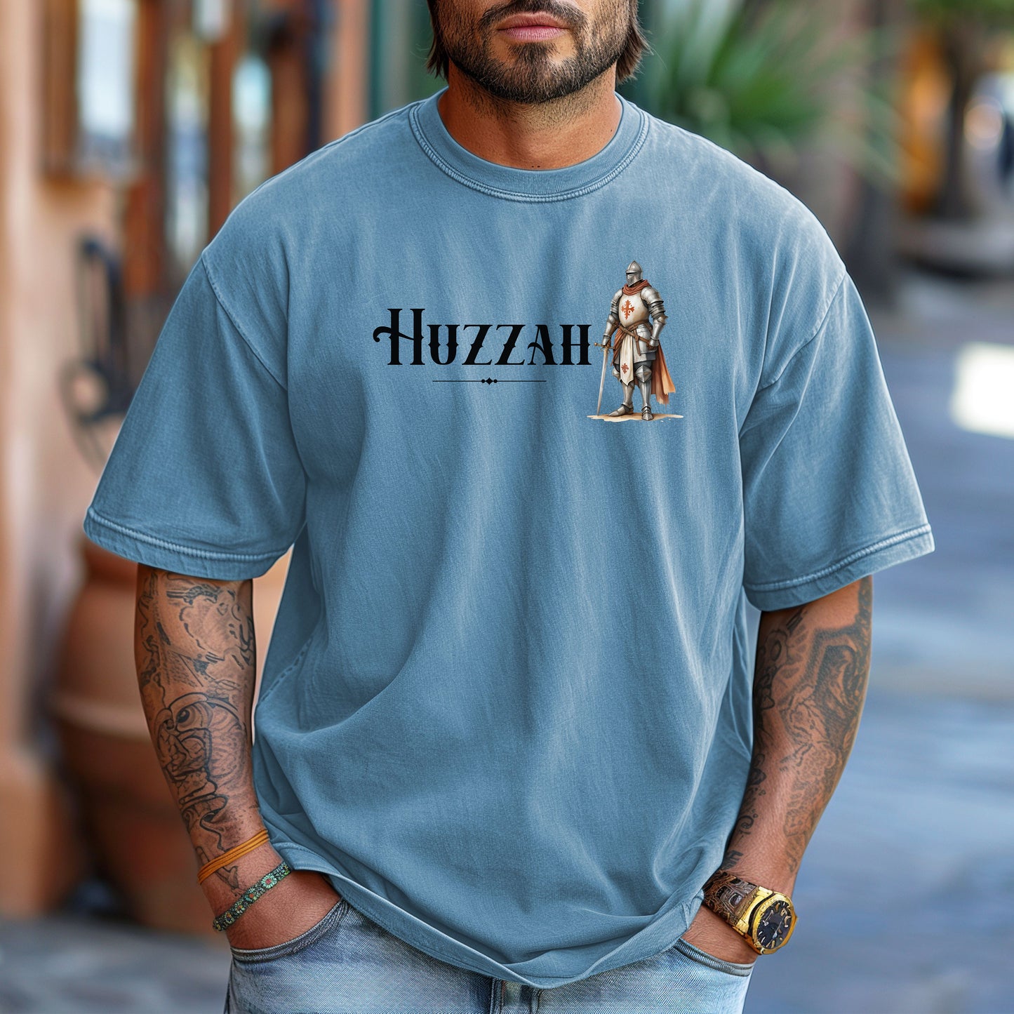 Washed Denim T-shirt featuring a Renaissance Faire design with the word “Huzzah” in medieval-style lettering and an illustration of a knight in shining armor. Perfect for Renaissance fair goers, medieval enthusiasts, and fans of historical festivals, celebrating the lively and spirited call of “Huzzah” at fairs and events.
