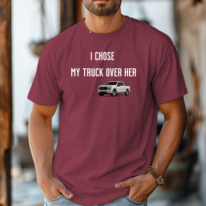 Chili T-shirt featuring the bold black text "I Chose My Truck Over Her" with a graphic of a white pickup truck beneath the words. The design has a humorous, confident tone, appealing to truck lovers and automotive enthusiasts. 
