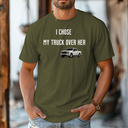Hemp color T-shirt featuring the bold black text "I Chose My Truck Over Her" with a graphic of a white pickup truck beneath the words. The design has a humorous, confident tone, appealing to truck lovers and automotive enthusiasts. 