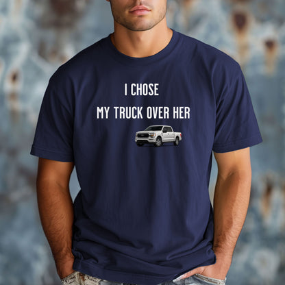 Navy  T-shirt featuring the bold black text "I Chose My Truck Over Her" with a graphic of a white pickup truck beneath the words. The design has a humorous, confident tone, appealing to truck lovers and automotive enthusiasts. 