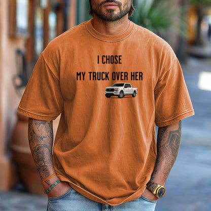 Yam T-shirt featuring the bold black text "I Chose My Truck Over Her" with a graphic of a white pickup truck beneath the words. The design has a humorous, confident tone, appealing to truck lovers and automotive enthusiasts. 