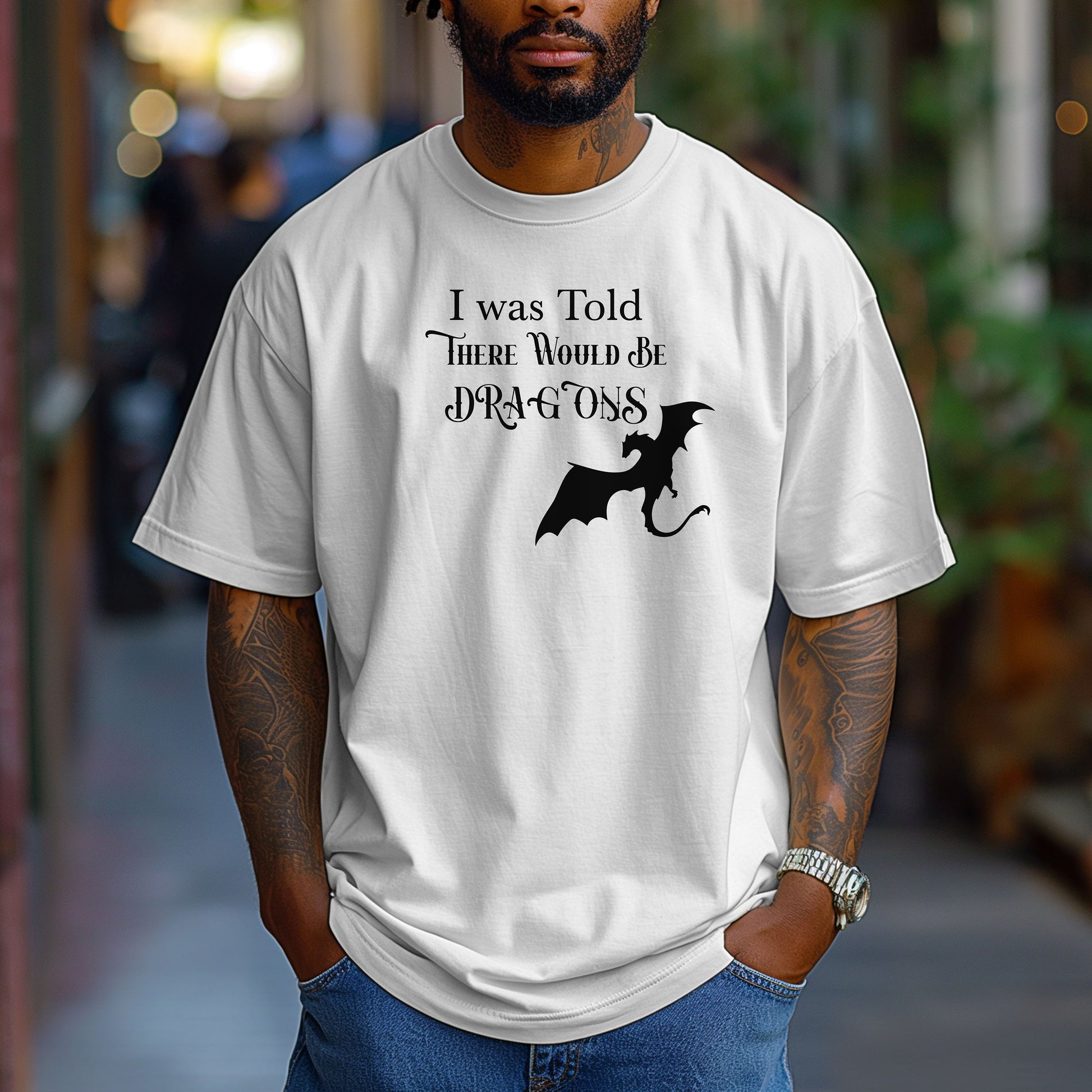 Person wearing a White T-shirt with a Renaissance Faire-inspired design that reads “I Was Told There Would Be Dragons” in medieval-style fonts. The graphic features a bold silhouette of a flying dragon, perfect for fantasy lovers and fairgoers who enjoy whimsical and mythical-themed apparel.
