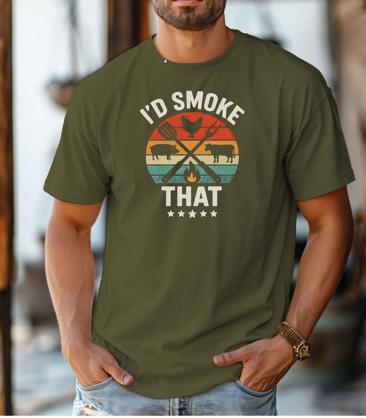 I’d Smoke That T-shirt featuring a retro sunset-style circle graphic with silhouettes of a chicken, pig, and cow, crossed grilling utensils, and a small flame. Text appears above and below the design, accented by five stars at the bottom. Printed on a hemp color unisex tee, this fun BBQ-themed shirt is perfect for grill masters, smoking enthusiasts, and meat lovers who enjoy cooking with humor.