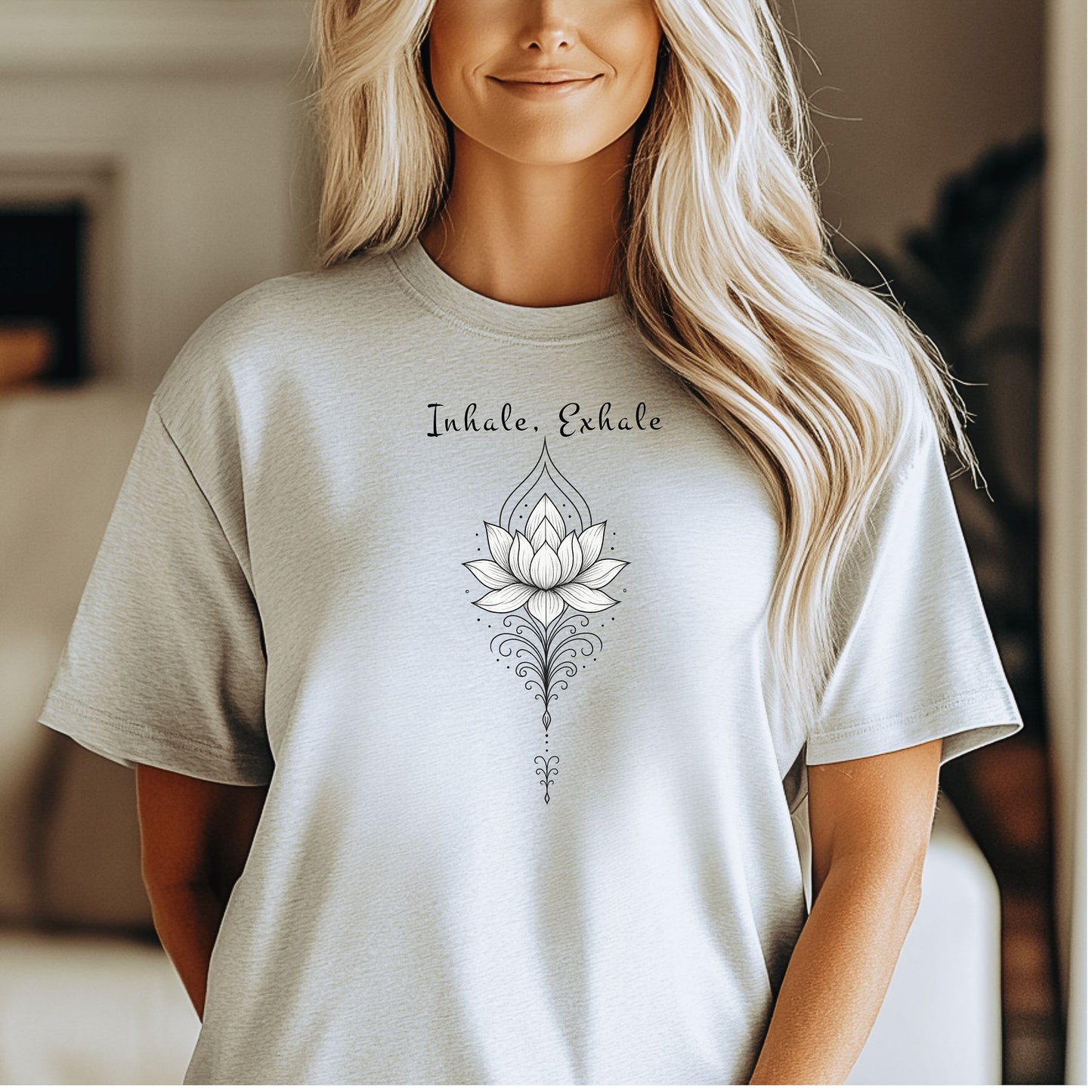 Person wearing an ash T-shirt featuring an elegant black line art lotus flower design with decorative flourishes, topped by the words “Inhale, Exhale” in a graceful script font. The minimalist, zen-inspired artwork conveys peace, mindfulness, and calm, making it perfect for yoga lovers, meditation enthusiasts, and those who embrace a serene, balanced lifestyle.
