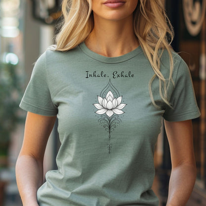 Person wearing a sage T-shirt featuring an elegant black line art lotus flower design with decorative flourishes, topped by the words “Inhale, Exhale” in a graceful script font. The minimalist, zen-inspired artwork conveys peace, mindfulness, and calm, making it perfect for yoga lovers, meditation enthusiasts, and those who embrace a serene, balanced lifestyle.