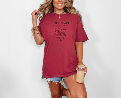 Person wearing a chili T-shirt featuring an “Inner Peace Comes from Within” design with a black line art lotus flower and elegant ornamental accents. The minimalist, symmetrical artwork conveys tranquility, mindfulness, and spiritual balance, making it perfect for yoga enthusiasts, meditation lovers, and those seeking calm, positive energy in their everyday style.