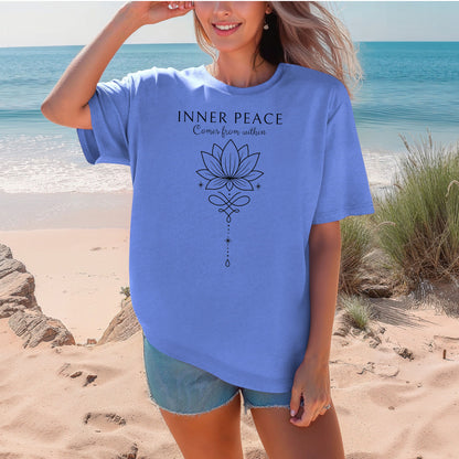 Person wearing a Flo Blue T-shirt featuring an “Inner Peace Comes from Within” design with a black line art lotus flower and elegant ornamental accents. The minimalist, symmetrical artwork conveys tranquility, mindfulness, and spiritual balance, making it perfect for yoga enthusiasts, meditation lovers, and those seeking calm, positive energy in their everyday style.