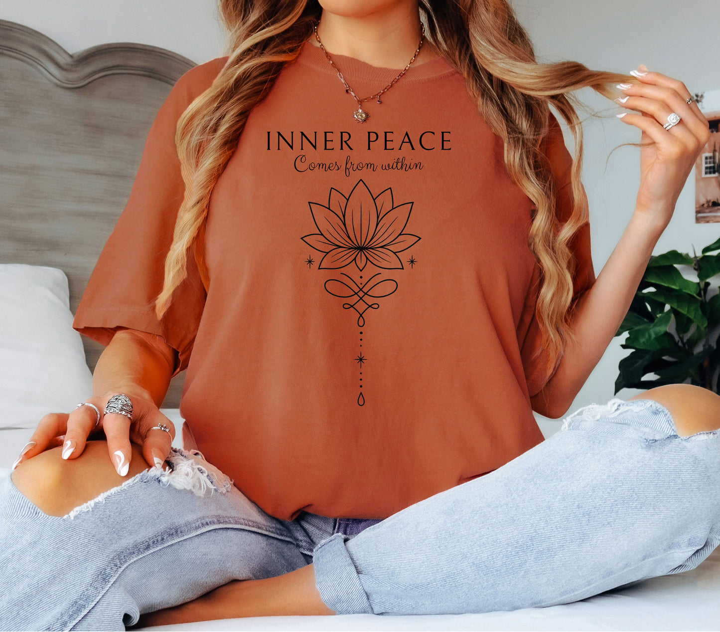 Person wearing a yam T-shirt featuring an “Inner Peace Comes from Within” design with a black line art lotus flower and elegant ornamental accents. The minimalist, symmetrical artwork conveys tranquility, mindfulness, and spiritual balance, making it perfect for yoga enthusiasts, meditation lovers, and those seeking calm, positive energy in their everyday style.