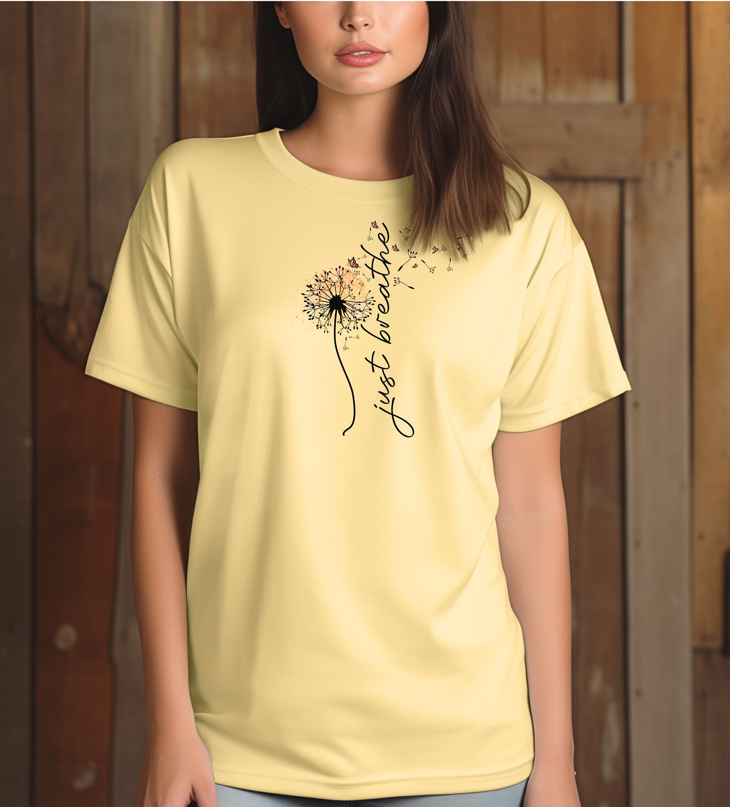 Just Breathe T-shirt featuring an artistic dandelion design with seeds blowing in the wind, transitioning into the handwritten phrase 'just breathe.' Printed on a soft, pastel banana unisex tee, this calming and inspirational graphic is perfect for promoting mindfulness, relaxation, and a peaceful mindset. Ideal for yoga lovers, nature enthusiasts, and casual everyday wear.