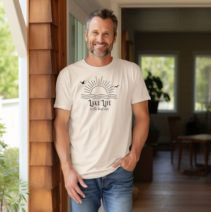 Person wearing a ivory T-shirt featuring a minimalist black line art design of a rising sun over wavy water, with two flying birds. The text reads “Lake Life is the best life” in elegant, mixed fonts. A relaxed, nature-inspired design perfect for lake lovers, summer days, and casual outdoor adventures.