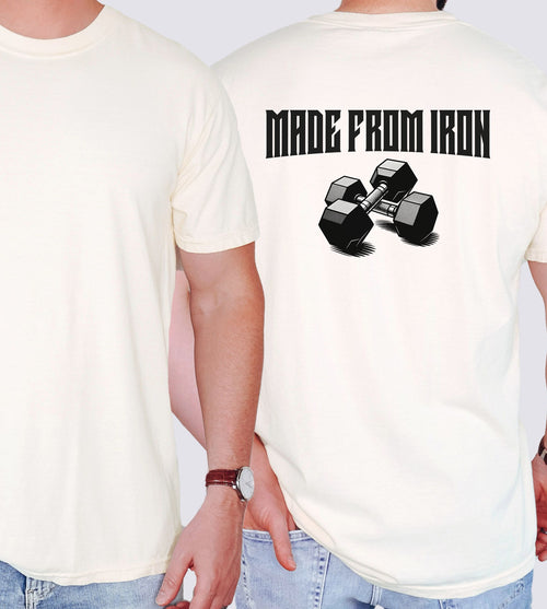 Person wearing an ivory T-shirt with a bold back design that reads “Made From Iron” in strong, block lettering above an illustration of two black dumbbells. The graphic captures a powerful, fitness-inspired aesthetic, perfect for gym enthusiasts, weightlifters, and strength training fans who want to showcase their dedication and passion for lifting.