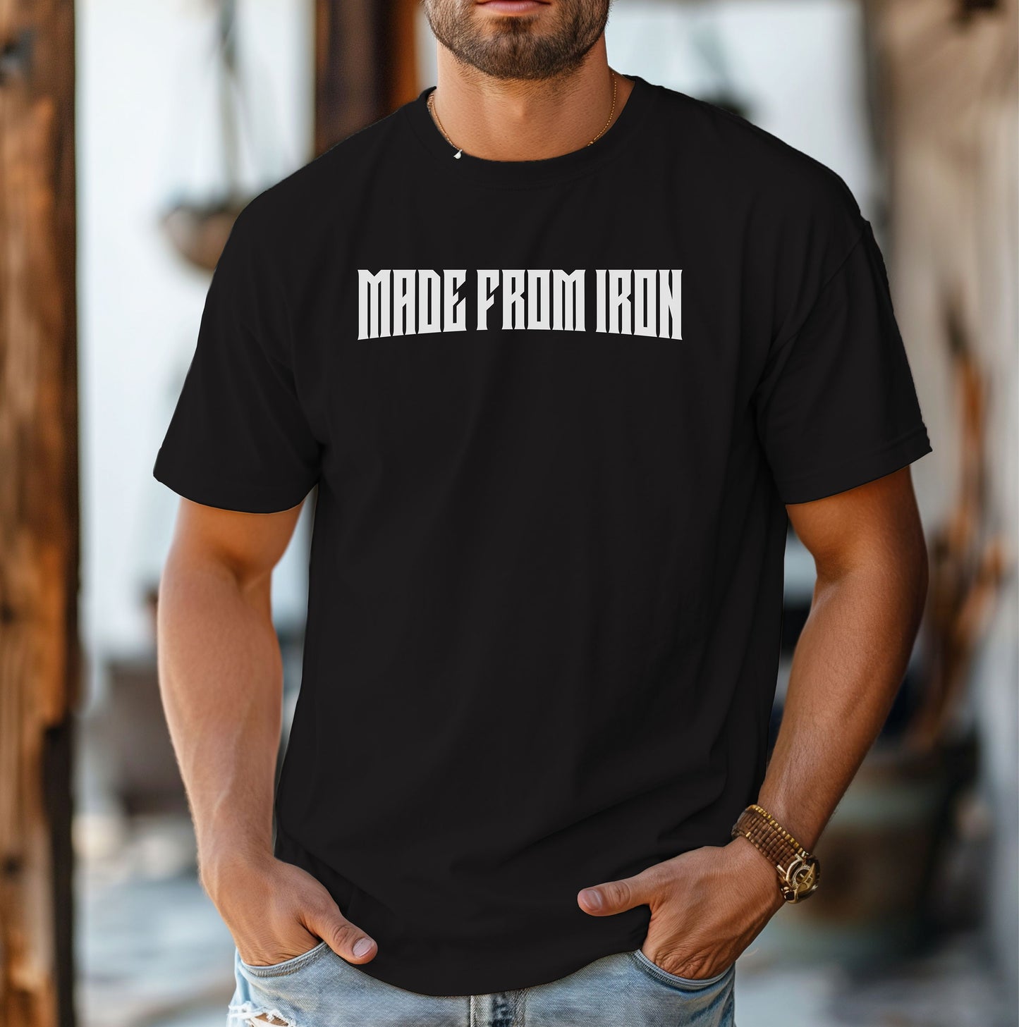 Person wearing a black T-shirt featuring the bold text “MADE FROM IRON” in a strong, arched black font across the chest. The design conveys strength, resilience, and determination, making it perfect for fitness enthusiasts, bodybuilders, and athletes who embrace a powerful mindset. Casual streetwear style with a rugged, motivational vibe ideal for workouts, training, or everyday wear.