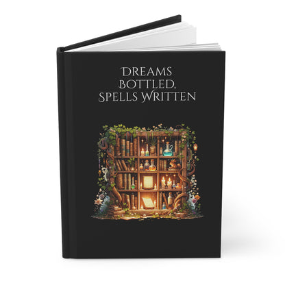 Open hardcover journal with a magical bookshelf illustration and text 'Dreams Bottled, Spells Written' on a black background.