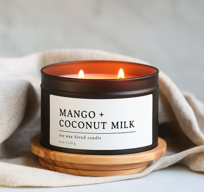Mango + Coconut Milk soy wax blend candle on a wooden coaster with a beige cloth background