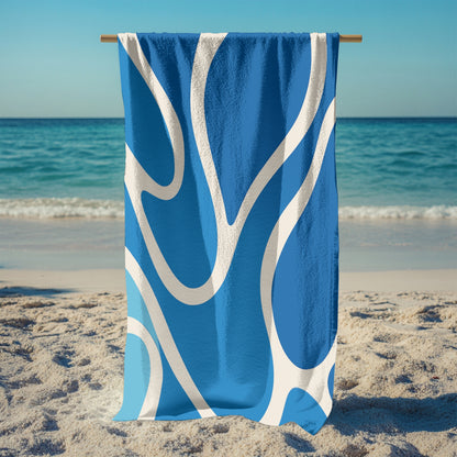 A stand holding up a beach towel with a modern abstract wave design in vibrant shades of blue and white. The curvy, fluid pattern evokes ocean movement, making it the perfect stylish and eye-catching accessory for summer beach days, poolside lounging, or tropical getaways.