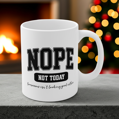 White ceramic mug with bold black collegiate text that reads “NOPE” and “NOT TODAY, tomorrow isn't looking good either” a humorous minimalist design for anyone in a not-today mood.