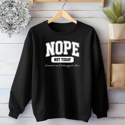 An Black sweatshirt with bold white text reading “NOPE NOT TODAY” and smaller script “tomorrow isn’t looking good either,” a humorous casual design for lazy days.