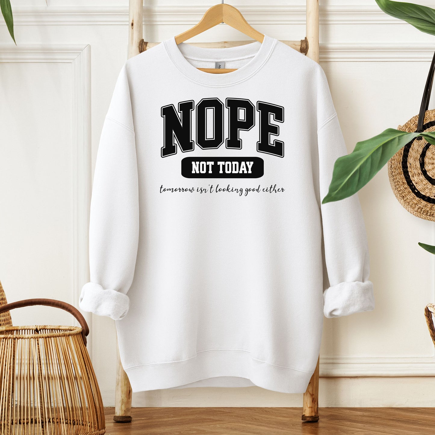 A White sweatshirt with bold white text reading “NOPE NOT TODAY” and smaller script “tomorrow isn’t looking good either,” a humorous casual design for lazy days.