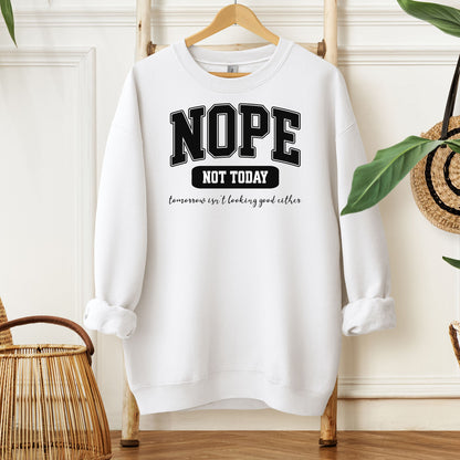 A White sweatshirt with bold white text reading “NOPE NOT TODAY” and smaller script “tomorrow isn’t looking good either,” a humorous casual design for lazy days.